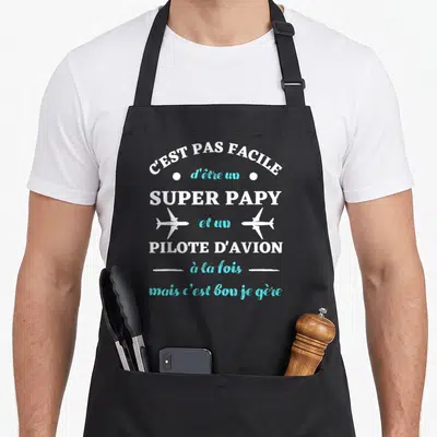 Tablier de cuisine noir avec texte blanc et turquoise C'est pas facile d'être un super papy et un pilote d'avion mais c'est bon je gère.