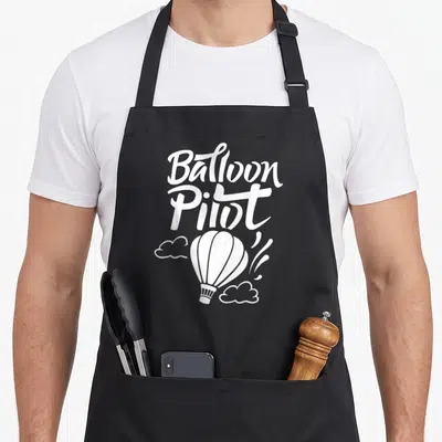 Tablier de cuisine noir avec l'inscription Balloon Pilot et une montgolfière blanche stylisée au centre.