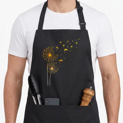 Tablier de cuisine noir avec illustration de pissenlits transformés en parachutes de parapente jaunes dorés.