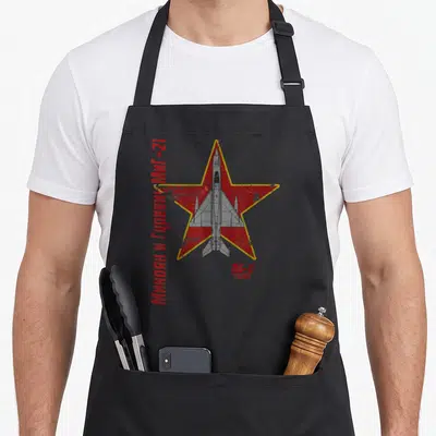 Tablier de cuisine noir avec illustration MiG-21 sur étoile rouge et texte cyrillique vertical.