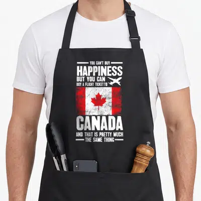 Tablier de cuisine noir avec un billet pour le Canada, un drapeau canadien rouge et blanc, et un avion blanc stylisé.