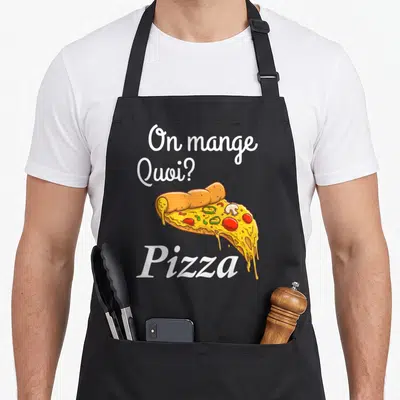 Tablier de cuisine noir avec l'inscription On mange Quoi ? Pizza et une illustration colorée d'une tranche de pizza garnie.
