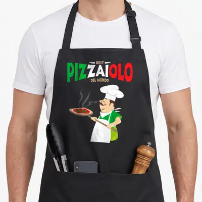 Tablier de cuisine noir avec un pizzaiolo souriant tenant une pizza et le texte Meilleur Pizzaiolo du monde en lettres vertes et rouges.