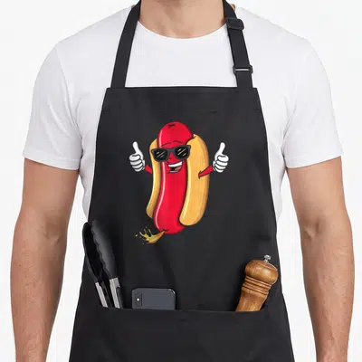 Tablier de cuisine noir avec un hot dog souriant en lunettes de soleil et deux pouces levés.