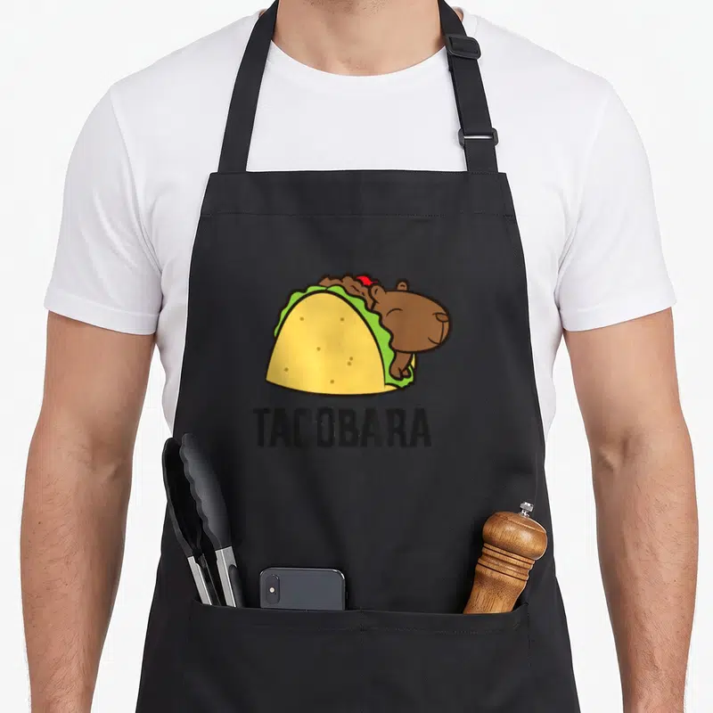 Tablier de cuisine noir avec illustration d'une capybara dans un taco et l'inscription TACOBARA.
