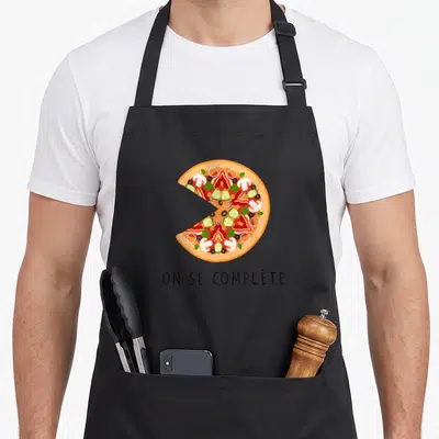 Tablier de cuisine noir avec une illustration colorée d'une part de pizza et un texte en bas.