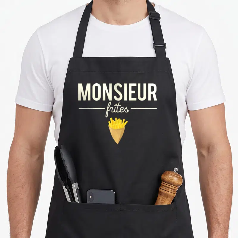 Tablier de cuisine noir avec inscription Monsieur Frites et illustration de patates frites dans un papier kraft.