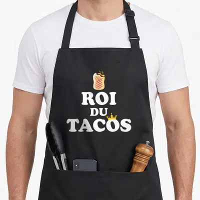 Tablier de cuisine noir avec un burrito fumant surplombant le texte Roi du Tacos en blanc et une couronne dorée.
