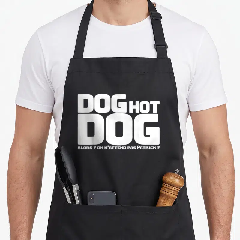 Tablier de cuisine noir avec le texte blanc Dog Hot Dog et une référence à Patrick en bas du motif typographique.