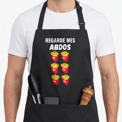 Tablier de cuisine noir avec inscription Regarde mes abdos et six illustrations de frites en carton rouge.