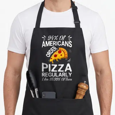 Tablier de cuisine noir avec une part de pizza et le texte 94% of Americans order pizza regularly en blanc.