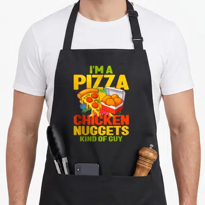 Tablier de cuisine noir avec une illustration colorée d'une pizza et de croquettes de poulet dans une boîte.