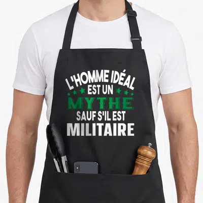 Tablier de cuisine noir avec le texte L'homme idéal est un mythe sauf s'il est militaire en blanc et vert.