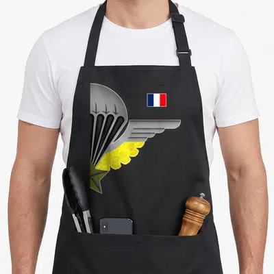 Tablier de cuisine noir avec une aile parachutiste, une étoile verte et le drapeau français en haut à droite.