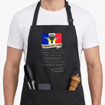 Tablier de cuisine noir avec le logo Saint-Michel, un parachute gris et une bannière beige sur fond tricolore français.