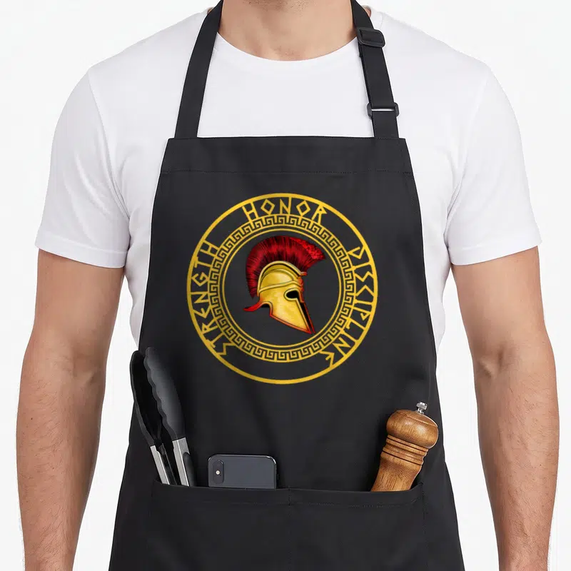 Tablier de cuisine noir avec casque spartiate doré et texte Force Honneur Discipline en cercle.