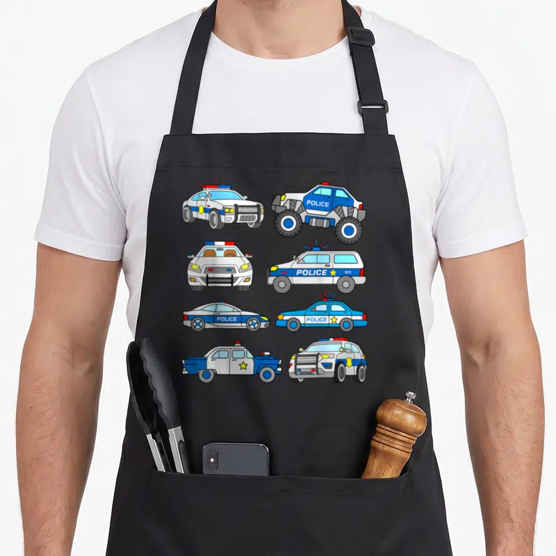 Tablier de cuisine noir avec illustration de voitures de police bleues blanches et véhicules 911 en style dessin animé.