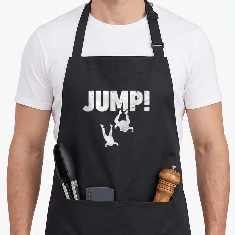 Tablier de cuisine noir avec l'inscription JUMP. et deux silhouettes de parachutistes en chute libre.