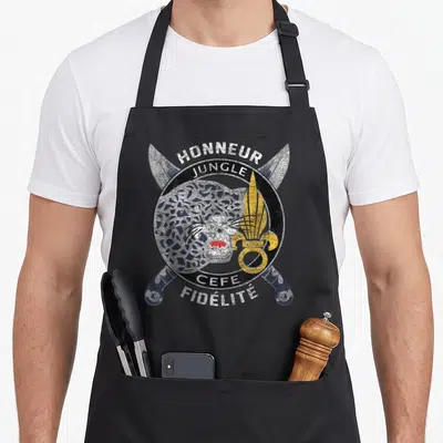 Tablier de cuisine noir avec un léopard, des épées croisées et les mots Honneur Jungle CEFE Fidelite imprimés en style délavé.