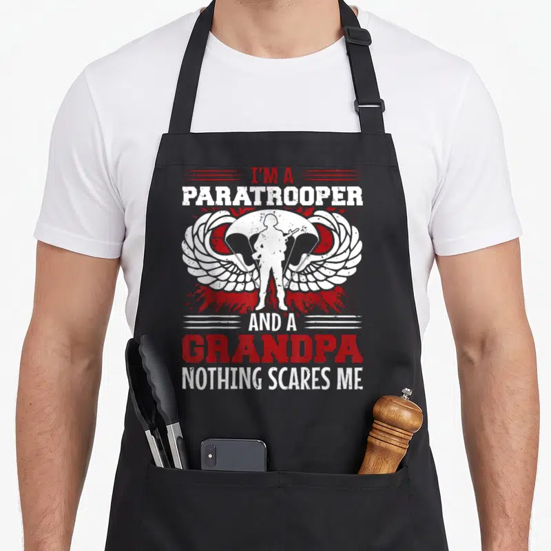Tablier de cuisine noir avec silhouette soldat parachutiste, ailes blanches et texte rouge I'm a Paratrooper and a Grandpa Nothing Scares Me.