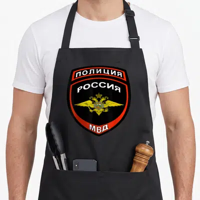 Tablier de cuisine noir avec un grand insigne POLICIA aux couleurs vives et au double aigle doré.