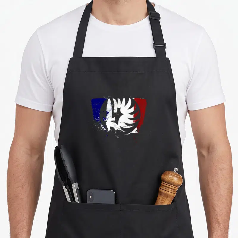 Tablier de cuisine noir avec un aigle blanc sur fond de traits bleus, blancs et rouges.