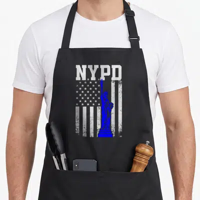 Tablier de cuisine noir avec inscription NYPD et silhouette bleue de la Statue de la Liberté devant des étoiles.