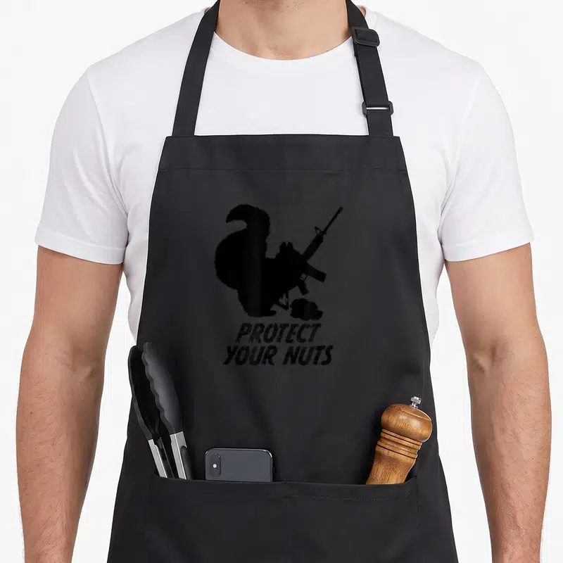 Tablier de cuisine noir avec silhouette écureuil tenant fusil AR15 et texte Protect Your Nuts en bas.