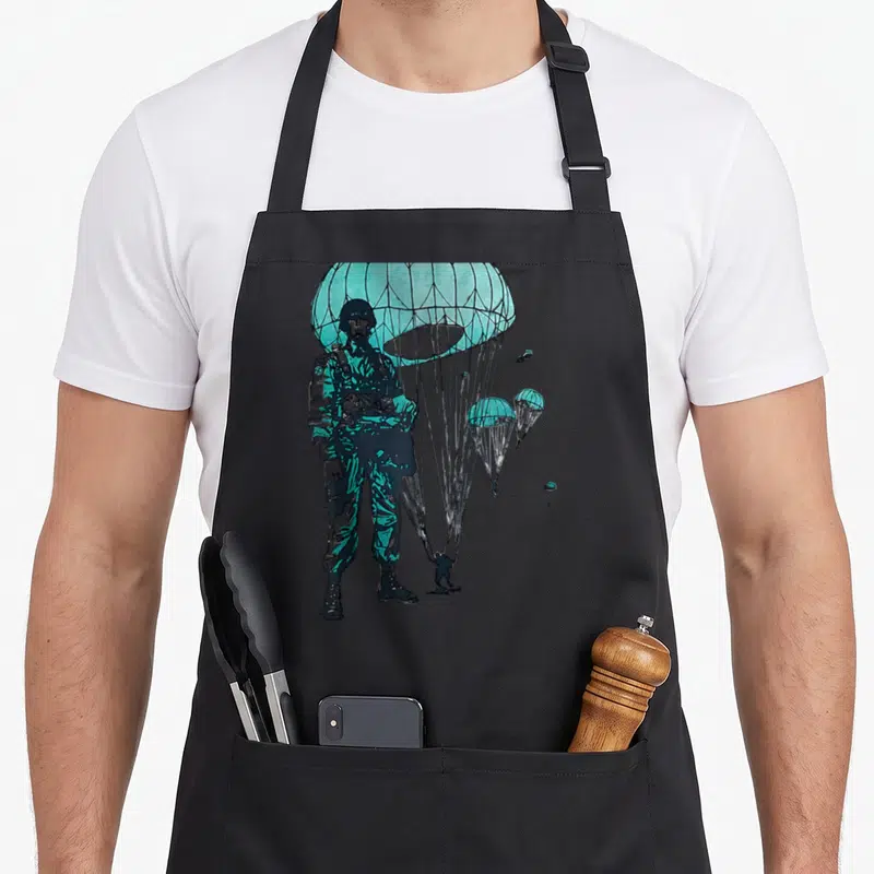 Tablier de cuisine noir avec illustration d'un parachutiste de l'armée aérienne sous une voile turquoise.