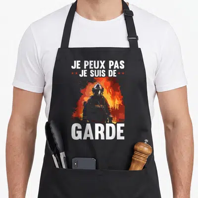 Tablier de cuisine noir avec silhouette de pompier et texte Je peux pas je suis de garde sur fond de feu.