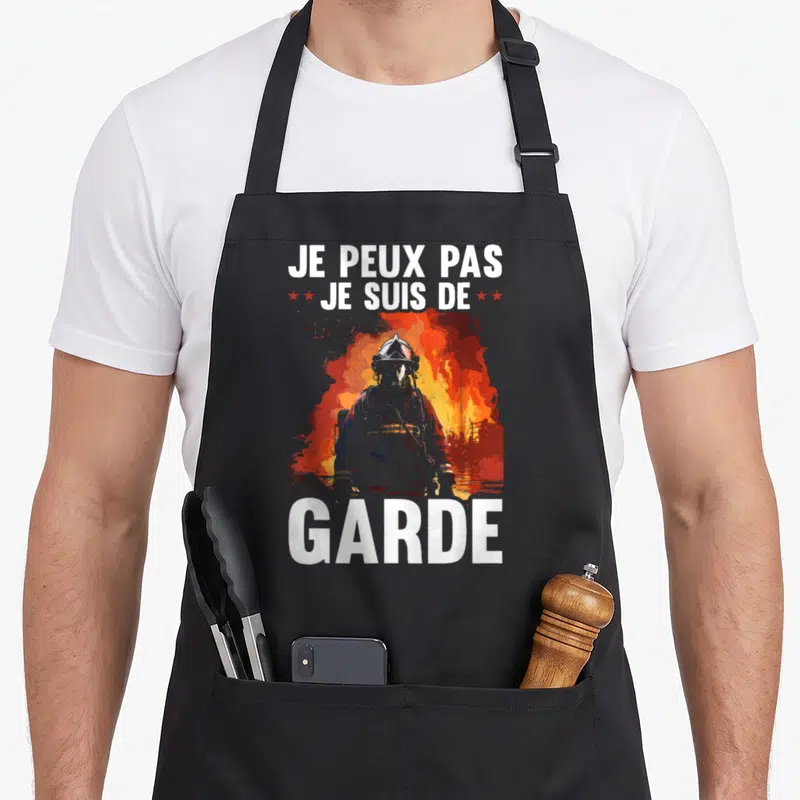Tablier de cuisine noir avec silhouette de pompier et texte Je peux pas je suis de garde sur fond de feu.