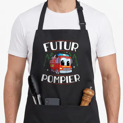 Tablier de cuisine noir avec un camion de pompiers rouge mignon et l'inscription futur pompier en blanc.
