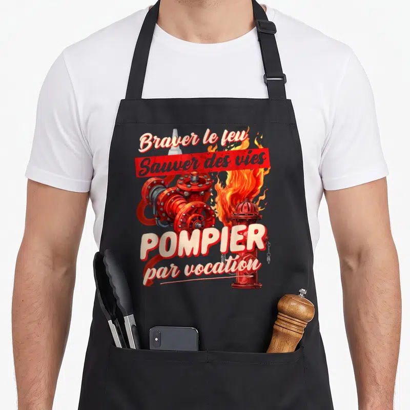Tablier de cuisine noir avec illustration de tuyau rouge, flammes et texte Pompier par vocation