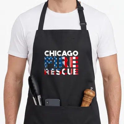 Tablier de cuisine noir avec le texte Chicago Fire Rescue stylisé aux étoiles et bandes rouges et bleues.
