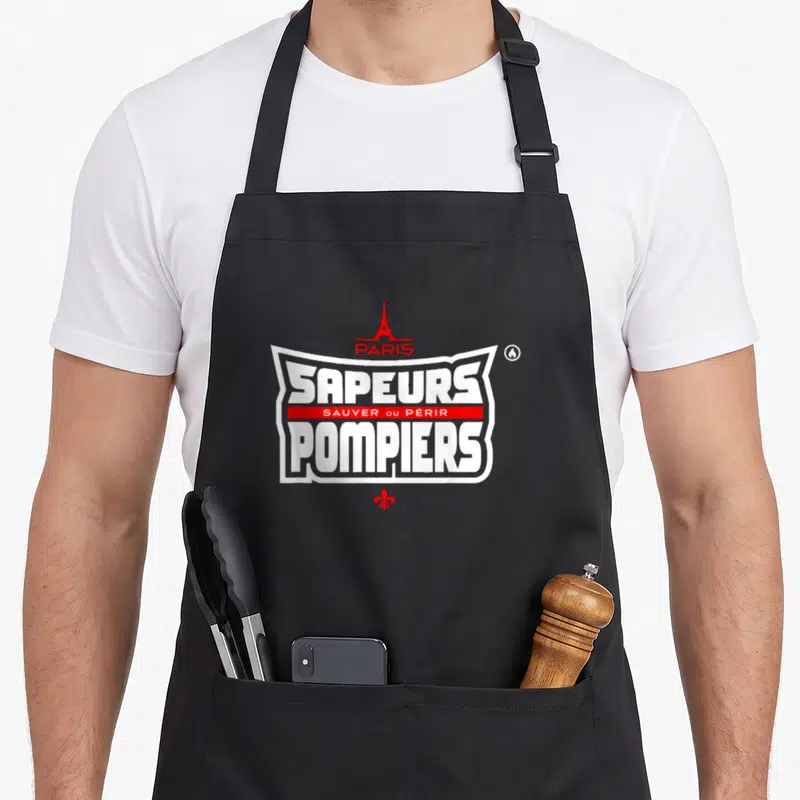 Tablier de cuisine noir avec logo Sapeurs Pompiers Paris, Tour Eiffel rouge et fleur de lys en bas du design.