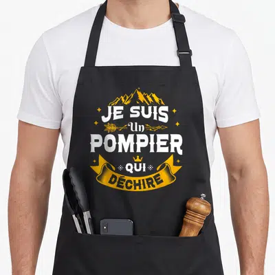 Tablier de cuisine noir avec inscription Je Suis Un Pompier Qui Déchire en blanc et or sur fond uni.