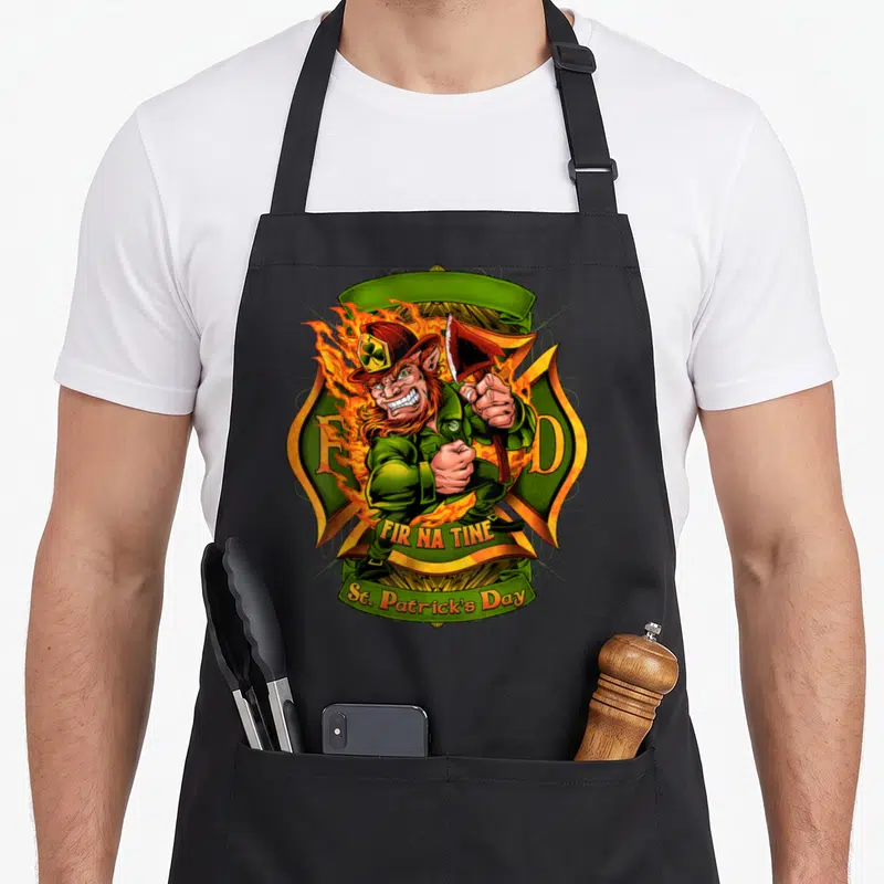 Tablier de cuisine noir avec un leprechaun pompier tenant une hache sur fond de croix de Malte verte et orange.