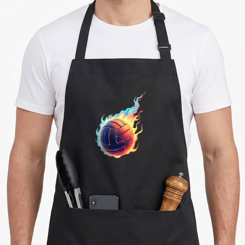 Tablier de cuisine noir avec un ballon de volleyball entouré de flammes bleues et oranges.