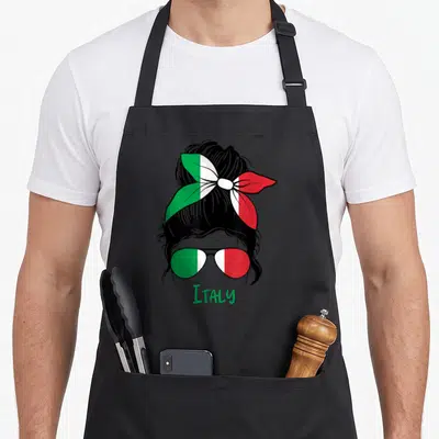 Tablier de cuisine noir avec une illustration de femme au chignon orné d'un foulard tricolore et de lunettes vertes, blanches et rouges.