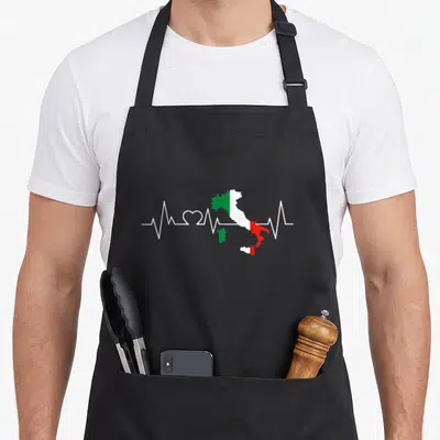 Tablier de cuisine noir avec carte d'Italie aux couleurs du drapeau et ligne de rythme cardiaque blanche formant un cœur.