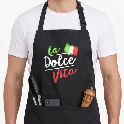 Tablier de cuisine noir avec linscription La Dolce Vita et une représentation artistique du drapeau italien aux couleurs vives.
