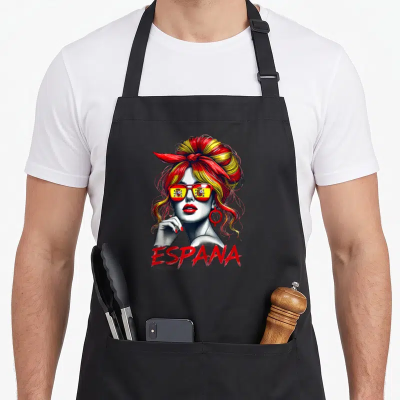 Tablier de cuisine noir avec une femme au chignon rouge et jaune portant des lunettes au drapeau espagnol et le mot ESPANA.