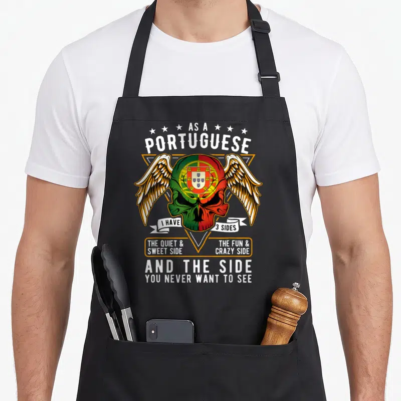 Tablier de cuisine noir avec une tête de mort aux couleurs du drapeau portugais et des ailes blanches.