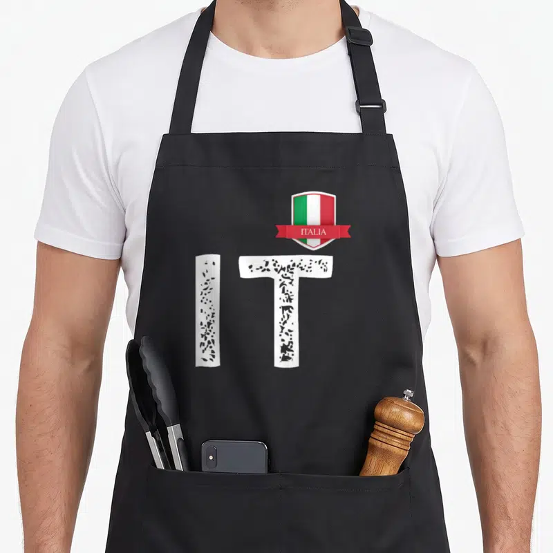 Tablier de cuisine noir avec les lettres IT en blanc érodé et un blason rouge vert blanc portant l'inscription ITALIA.