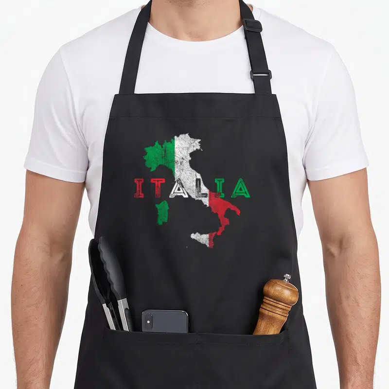 Tablier de cuisine noir avec une carte de l'Italie aux couleurs du drapeau et le mot Italia en lettres colorées.
