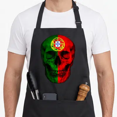 Tablier de cuisine noir avec une tête de mort peinte aux couleurs du drapeau portugais vert et rouge.