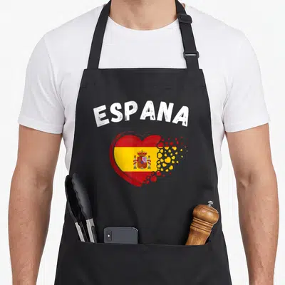 Tablier de cuisine noir avec le mot Espana et un cœur rouge jaune au drapeau espagnol fragmenté en petits cœurs.