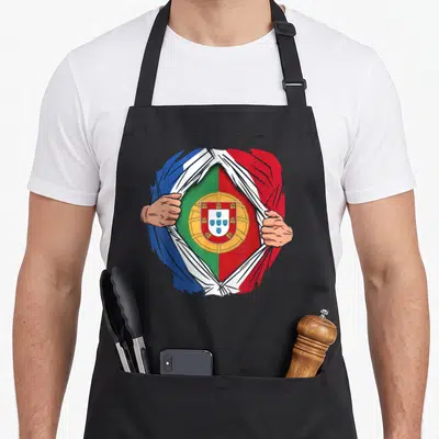 Tablier de cuisine noir avec un super-héros déchirant son costume français pour montrer le drapeau du Portugal.