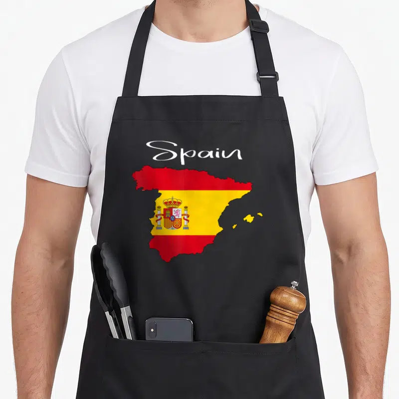 Tablier de cuisine noir avec carte de l'Espagne aux couleurs du drapeau et le mot Spain en écriture cursive blanche.