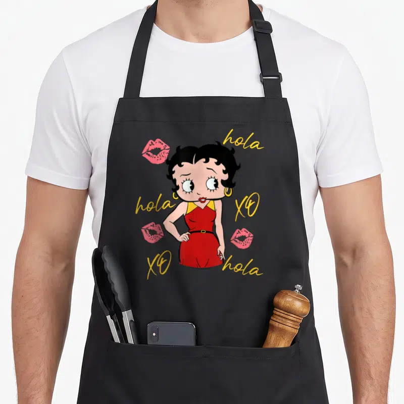 Tablier de cuisine noir avec Betty Boop en robe rouge entourée de hola et de baisers roses.